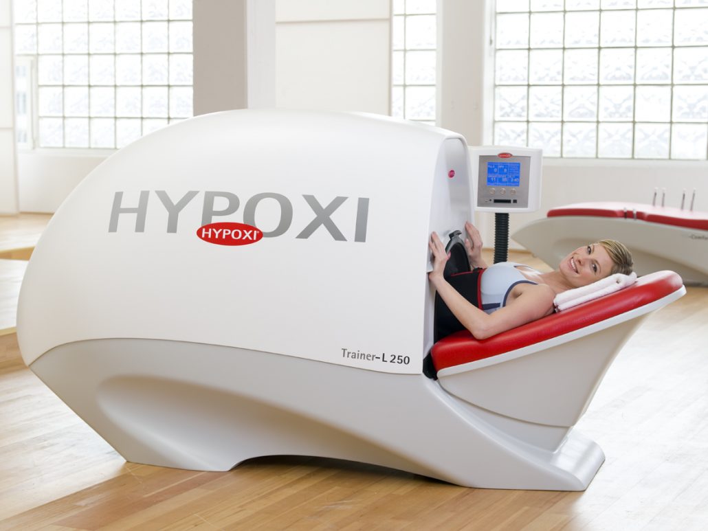 Kundin entspannt lächelnd während der HYPOXI-Behandlung im Liegegerät
